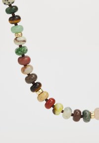 Κολιέ με χάντρες που περιλαμβάνει στρογγυλές πέτρες σε διάφορα χρώματα: πράσινο, καφέ, κόκκινο, κίτρινο, με χρυσές λεπτομέρειες και λεία, γυαλιστερή υφή.