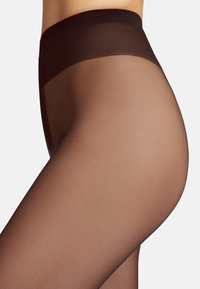 Gennemsigtige strømpebukser, brun farve, semi-opaque med en glat tekstur. Bred elastisk talje ved toppen, der overgår til gennemsigtigt materiale nedenunder.