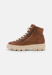 Sneaker montante en cuir marron avec une finition texturée, lacets crème, fermeture éclair sur le côté et semelle épaisse beige. Présente un logo en relief.