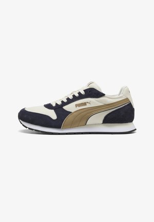 Sneaker Puma a basso profilo in beige, camoscio blu navy e pelle color cuoio con lacci bianchi e suola bianca, vista di lato.