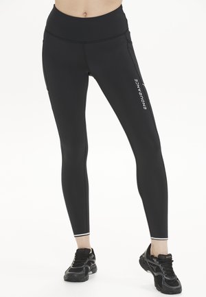 Zwarte leggings van rekbaar materiaal, met een hoge tailleband, slim fit en reflecterende accenten. Inclusief een zijzak.
