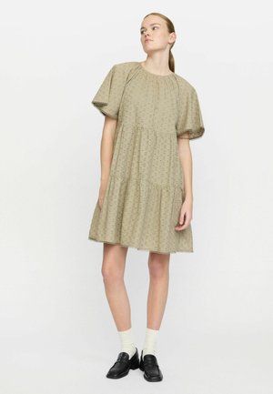 Light beige, embroidered cotton dress with short puff sleeves, tiered design, scalloped hem, and subtle floral patterns.