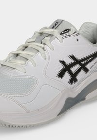 Λευκό και γκρι αθλητικό παπούτσι Asics με κορδόνια, μαύρο λογότυπο στο πλάι και υφή στην σόλα για καλύτερη πρόσφυση.
