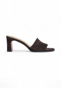 Mules à talons hauts en daim marron foncé avec une large bande avant et un bout ouvert carré. Dotés d'un talon épais et géométrique. Texture lisse.