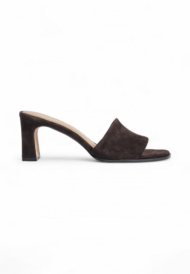 Mules à talons hauts en daim marron foncé avec une large bande avant et un bout ouvert carré. Dotés d'un talon épais et géométrique. Texture lisse.