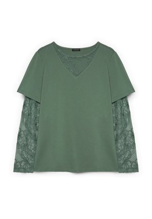 Top verde de manga larga con mangas cortas sólidas superpuestas a mangas de encaje floral transparente y una inserción de encaje en forma de V a juego.