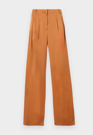 Pantalon ample couleur rouille avec plis, passants pour ceinture et fermeture éclair cachée à l'avant, présenté à plat sur un fond blanc.