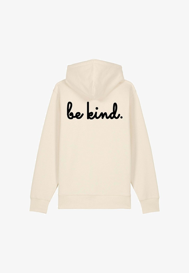 Sweat à capuche beige avec un cordon de serrage. Le dos arbore le texte "sois gentil." en police cursive noire. Texture lisse, design décontracté.