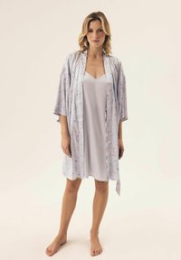 Świetlisty szary satynowy szlafrok z kwiatowym wzorem, z krótkimi rękawami kimono i wiązaniem w talii, nałożony na pasującą sukienkę slip. Gładka tekstura.