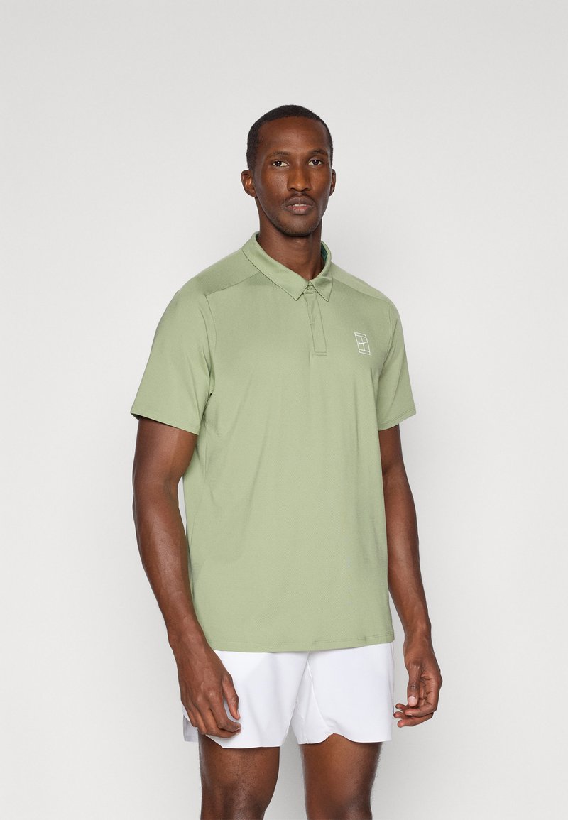 Kortermet polo skjorte i lys grønn, laget av teksturert stoff, med en tre-knapps placket og en liten brodert logo på brystet.