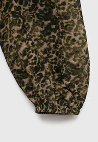 Ærme af grøn og brun leopardprintet stof med elastisk manchet, lagt fladt på en lys baggrund.