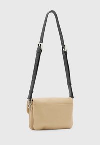 Borsa a tracolla beige in pelle con una texture morbida, tracolla nera regolabile, accessori in argento e apertura con zip.