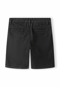 Svarta shorts gjorda av ett slätt tyg. Har en platt midjeband, två bakfickor utan synliga stängningar och stickade detaljer runt kanterna.