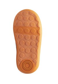 Semelle de chaussure en caoutchouc orange avec une surface texturée comportant des cercles surélevés et des motifs ondulés, conçue pour l'adhérence et la durabilité.