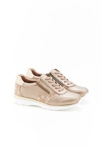 Sneaker beige con una superficie testurizzata e variabile, con lacci e cerniere laterali. Suola in gomma bianca, accentuata da tappi per il tallone di un beige chiaro.