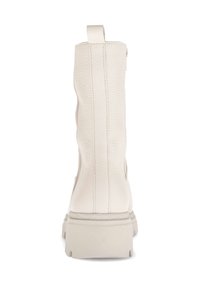 White leather ankle boot with a textured finish, a pull tab at the back, and a chunky beige sole. Vertical seam detailing on the sides.