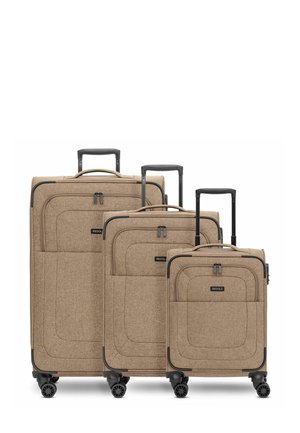 Trois valises en tissu beige de tailles variées avec des roues et des poignées noires. Chacune possède une surface lisse avec une texture subtile et des détails de couture.
