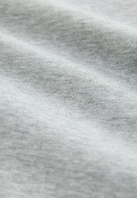Hellgrauer Stoff mit einer weichen, glatten Textur und leichtem Stretch; zeigt subtile Farbtöne und Muster, die seine gewebte Struktur hervorheben.