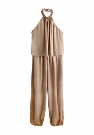 Bézs színű ujjatlan overál pántos nyakkal, laza, áramló felső résszel, széles szárakkal és ráncolt, elasztikus szegéllyel ellátott nadrágszárral.