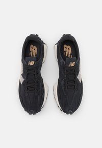 Czarne zamszowe sneakersy z teksturowanym beżowym panelem bocznym, z zapięciem na sznurówki, gumową podeszwą i logo na języku.