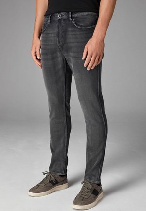 Jeans negre de denim cu o croială slim, având un design clasic cu cinci buzunare și o textură ușor estompată. Asortați cu adidași negri.