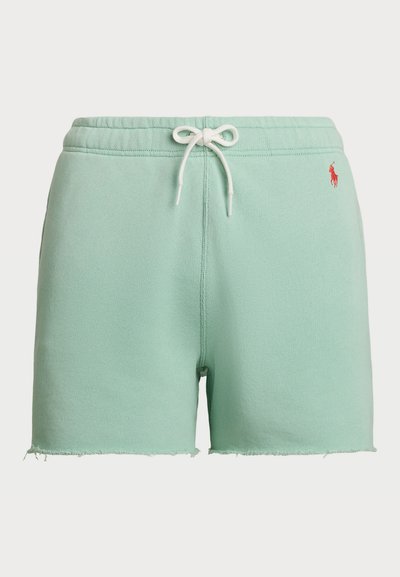 Shorts de algodão verde menta com cintura ajustável por cordão, bainha desfiada e um pequeno logotipo vermelho no lado esquerdo. Textura suave, design casual.