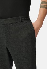 Donkergrijze tapered broeken van textuurstof, met een tailleband en zijzakken voor een strak uiterlijk.