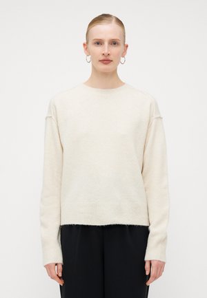 Cream-colored, soft knit sweater with a round neck, dropped shoulders, and ribbed cuffs and hem. Textured finish, relaxed fit.