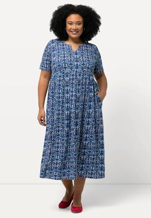 Sininen kuviollinen midi-mekko, jossa on lyhyet hihat, V-pääntie, taskut ja val flowy-siluetti, jossa on monimutkaisia valkoisia ja punaisia kuvioita.