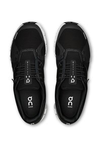 Fekete sportcipők hálós felsőrésszel, rugalmas fűzőkkel és párnázott talpbetéttel. Fehér talppal és a nyelven elhelyezett márkajelzéssel.