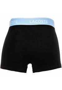  boxer da uomo neri con elastico azzurro chiaro che presenta il marchio "LACOSTE" in bianco ripetuto lungo tutta la circonferenza.