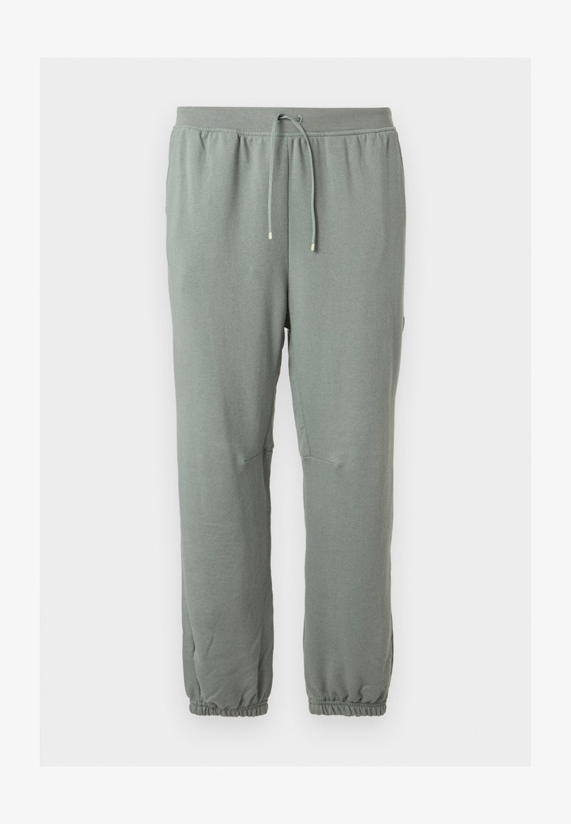 Pantalon de survêtement vert clair avec cordon de serrage, taille et poignets élastiques, présenté sur un fond uni.