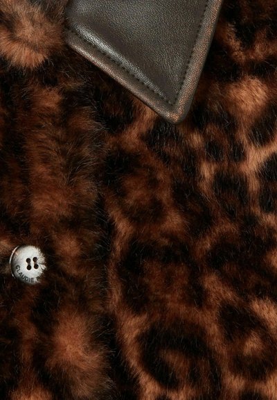 Tessuto in pelliccia sintetica con stampa leopardata in toni marroni, caratterizzato da un dettaglio in pelle nera e un bottone argentato con la scritta "CLAUDIE" incisa.