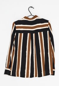 Camicia a maniche lunghe a righe in marrone, crema e nero. Presenta un colletto e polsini con bottone. Tessuto morbido con vestibilità comoda e piega sul retro.