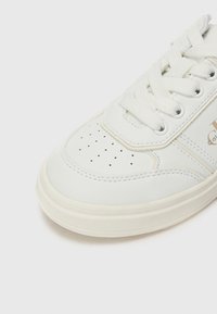 Baskets en cuir blanc avec bout perforé, design lacé et semelle en caoutchouc. Présente des éléments de marque sur le côté et des détails de coutures contrastantes.