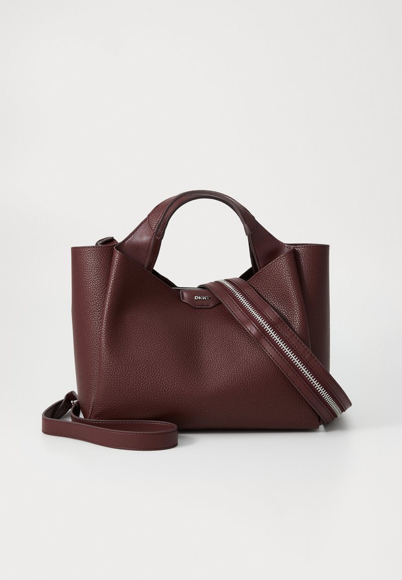 Bolsa de mão em pele burgundy com um acabamento texturizado, duas alças curtas e uma alça de ombro removível com detalhe em fecho de correr prateado.