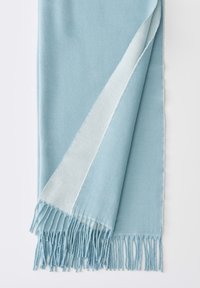 Sciarpa azzurra chiara realizzata in materiale morbido, con un design elegante, una bordatura bianca lungo un lato e le estremità frangia.