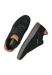 Baskets en daim noir avec semelles en caoutchouc gris foncé. Présentent des accents marron sur le talon et la languette. Design classique à lacets. Panneau latéral texturé.