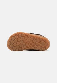Suola di scarpa marrone con motivo a forma di cerchio; materiale in gomma; logo del marchio "bisgaard" visibile; taglia contrassegnata come "22."