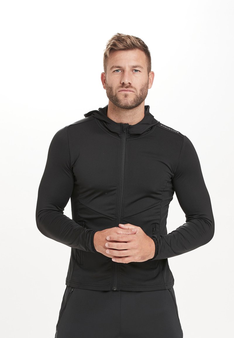 Sort atletisk zip-up jakke med hætte, tætsiddende design, lange ærmer, glat tekstur og lynlåslommer på siderne.