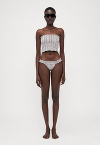 Conjunto de bikini de duas peças com riscas, apresentando um top bandeau com bordas rendadas e calções de cintura baixa, feito de um tecido leve em várias cores.