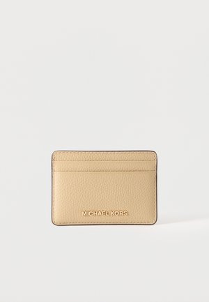 Beiger strukturierter Kartenhalter mit drei Kartenfächern und dem „Michael Kors“ Logo in goldenen Buchstaben in der vorderen Mitte.