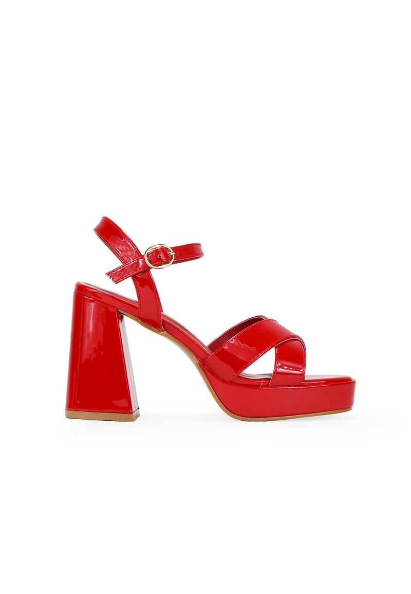Sandalias de plataforma de charol rojo con un chunky heel, tiras en el tobillo con un cierre dorado y múltiples tiras cruzadas en la puntera.