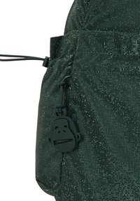 Zaino verde realizzato in materiale testurizzato con un motivo a griglia, dotato di un tirazip a forma di scimmia e chiusura con coulisse.