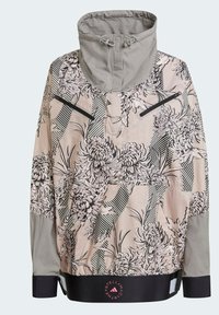 Giacca leggera con un motivo floreale e a righe in beige e nero. Dotata di un collo alto, tasche con zip e dettagli sui polsini.