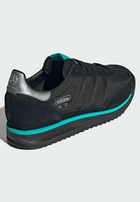 Black Adidas SL '72 sneakers with a suede and textile upper. Features turquoise accents and a silver heel with Mercedes logo. Rubber sole.