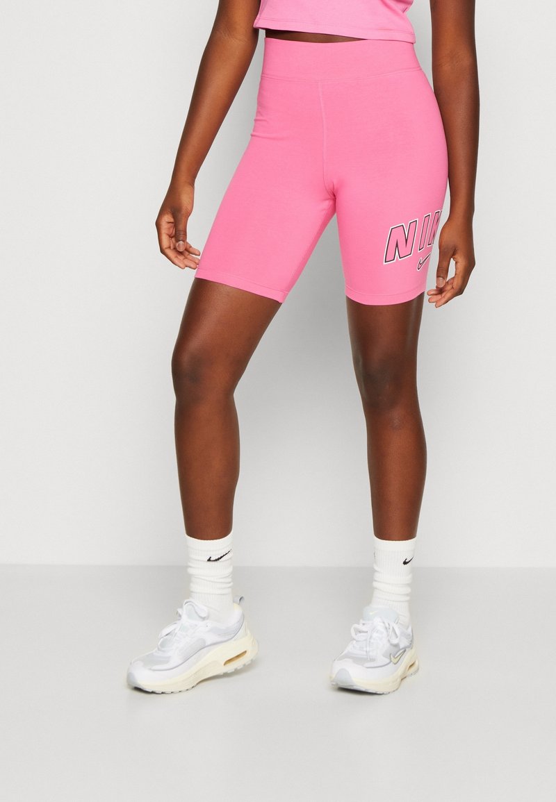 Tight passande rosa cykelbyxor med hög midja och tryckt "NIKE"-logotyp på sidan. Tillverkade av stretchigt material, med en mjuk textur.