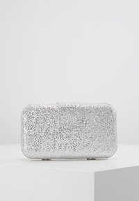 Sac à main argenté de forme rectangulaire, recouvert de strass scintillants, avec un fermoir plat et une texture lisse.