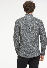 Langearmige shirt in een donkergroen bloemenpatroon met grijze accenten. Gemaakt van zachte stof, met een klassieke kraag en knoopmanchetten.