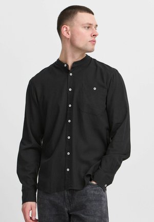 Black long-sleeve shirt featuring a stand collar, button front, single chest pocket, and white buttons. Soft fabric with a smooth texture.